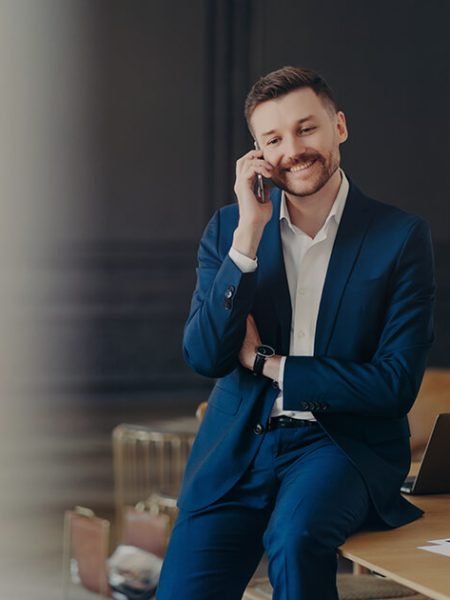 happy-handsome-businessman-talking-on-phone-while-2022-02-22-15-38-08-utc.jpeg