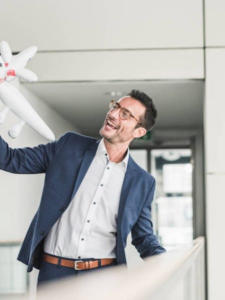 laughing-businessman-playing-with-toy-aeroplane-in-2022-11-06-23-19-34-utc.jpg